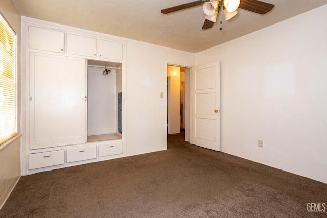 unfurnished bedroom with ceiling fan, multiple windows, and carpet flooring