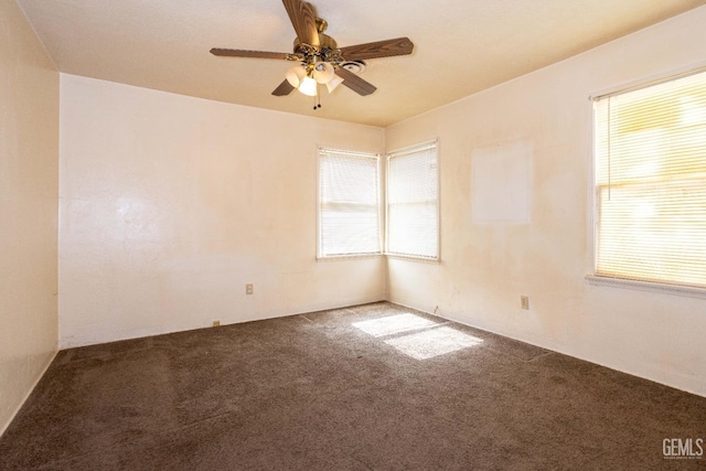 empty room with carpet floors, a wealth of natural light, and a ceiling fan