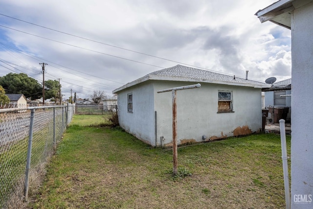 view of property exterior with a fenced backyard, a lawn, and stucco siding