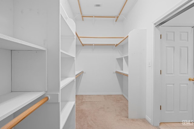 spacious closet featuring light colored carpet