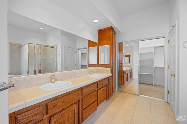 bathroom with vanity, a shower with shower door, and tile patterned flooring