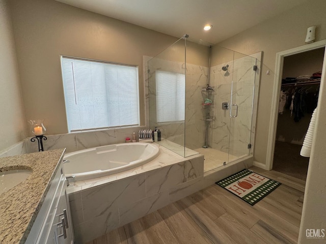 bathroom with shower with separate bathtub, vanity, and hardwood / wood-style flooring