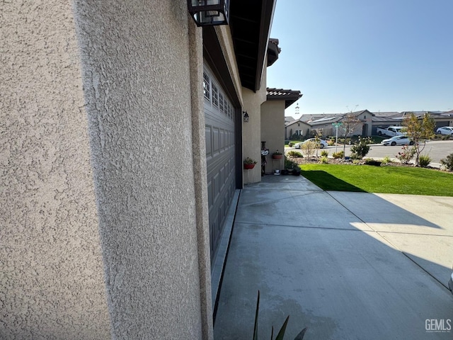 view of side of home featuring a garage and a yard