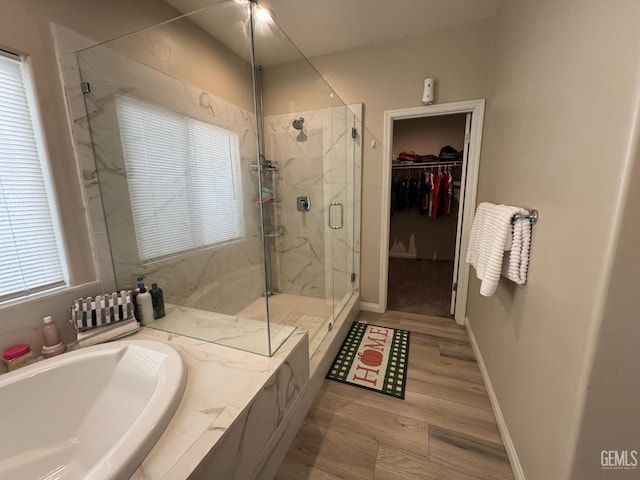 bathroom with hardwood / wood-style floors, shower with separate bathtub, and plenty of natural light