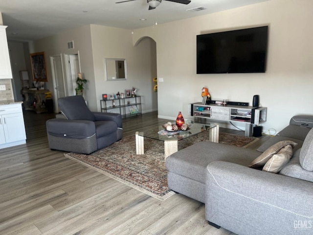 living room with light hardwood / wood-style floors and ceiling fan