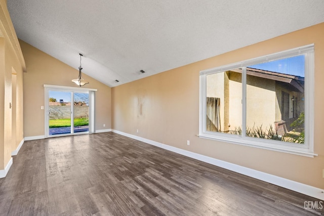 unfurnished room featuring dark hardwood / wood-style floors, vaulted ceiling, and a textured ceiling