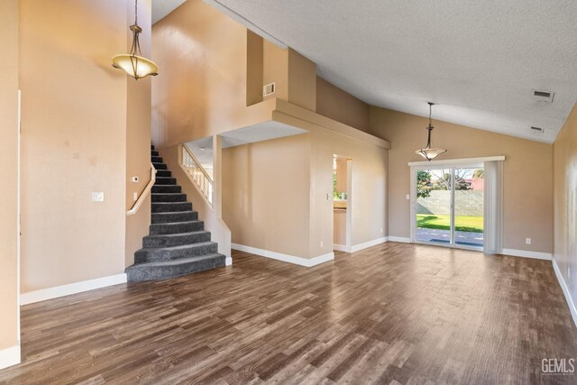 unfurnished living room featuring hardwood / wood-style flooring, vaulted ceiling, and a textured ceiling