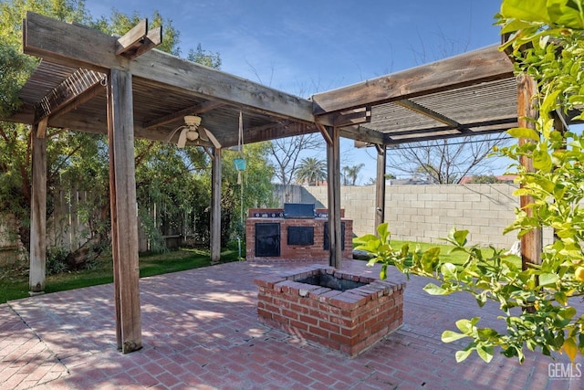 view of patio / terrace with ceiling fan, an outdoor kitchen, a pergola, and a fire pit