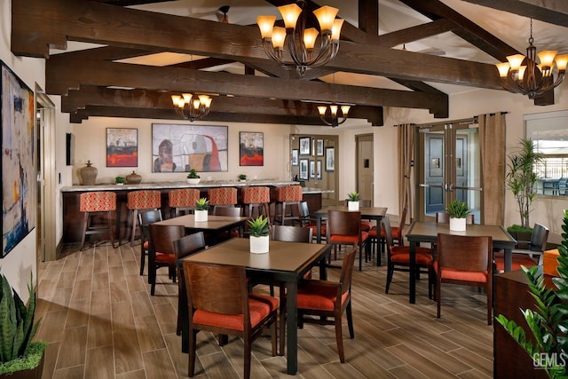 dining area with wood tiled floor, french doors, a notable chandelier, and beamed ceiling