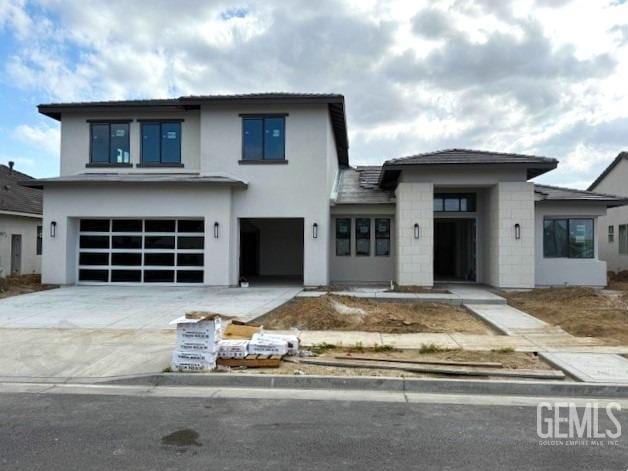 view of front facade featuring concrete driveway, a garage, stucco siding, and concrete block siding