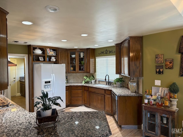 15725 Marty Ave, Bakersfield, CA 93314 - kitchen featuring white refrigerator with ice dispenser, stone countertops, stainless steel dishwasher, glass insert cabinets, and decorative backsplash