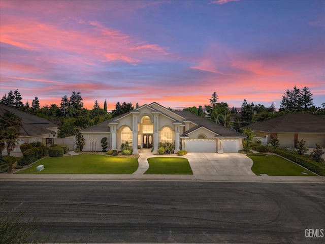 mediterranean / spanish home with a lawn and a garage