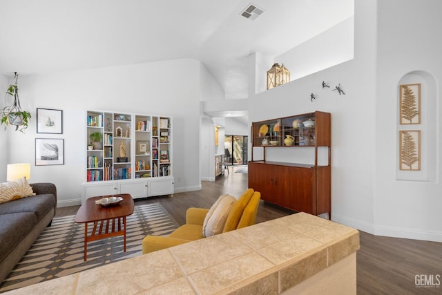 living room featuring high vaulted ceiling and dark wood-type flooring