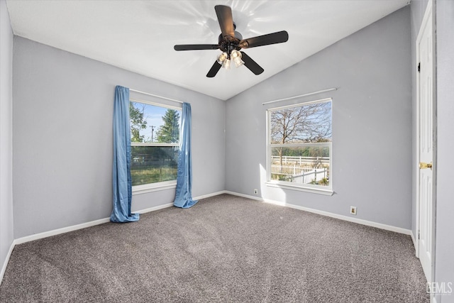 empty room with a ceiling fan, carpet, vaulted ceiling, and baseboards