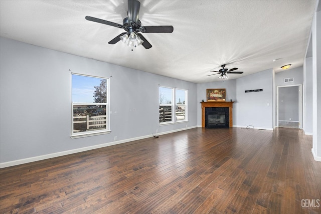 unfurnished living room featuring a fireplace, wood-type flooring, ceiling fan, a textured ceiling, and baseboards