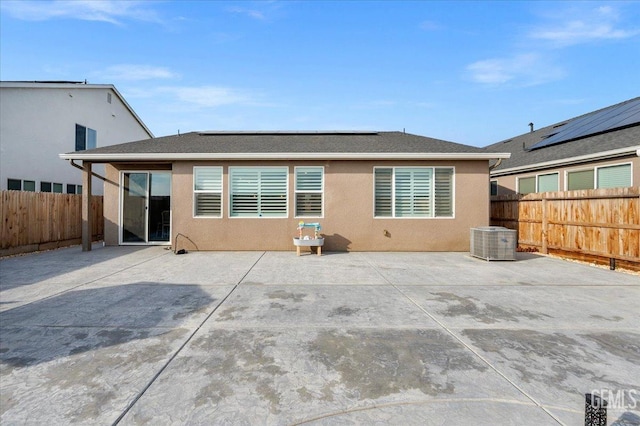 back of property featuring a patio, central AC unit, a fenced backyard, and stucco siding