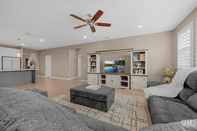 living room featuring a ceiling fan, visible vents, baseboards, recessed lighting, and light wood-style floors