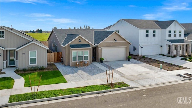 view of front facade with board and batten siding, concrete driveway, and fence