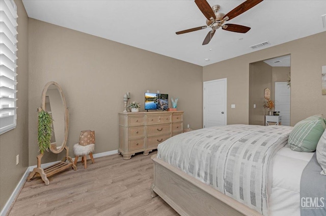 bedroom featuring visible vents, a ceiling fan, light wood-type flooring, and baseboards