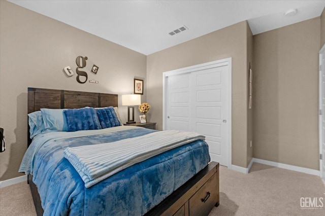 bedroom with light colored carpet, visible vents, a closet, and baseboards