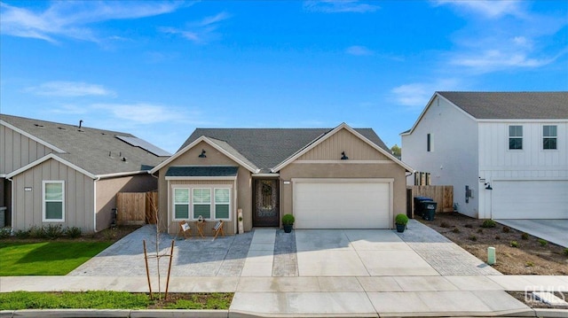 view of front of house with an attached garage, fence, and driveway