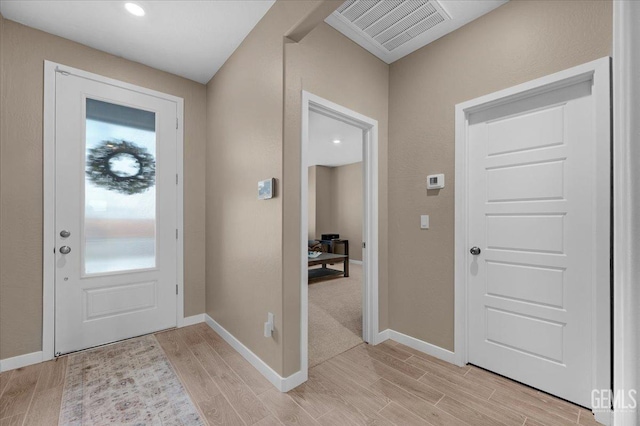 entrance foyer with baseboards, visible vents, and wood finish floors