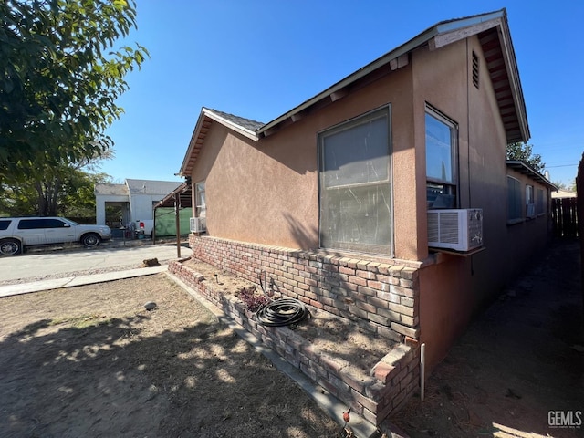 view of home's exterior with cooling unit and stucco siding