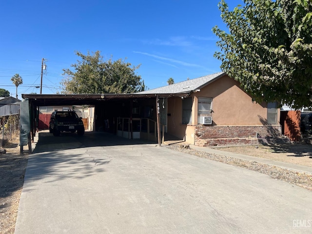 ranch-style home with stucco siding, an attached carport, and driveway