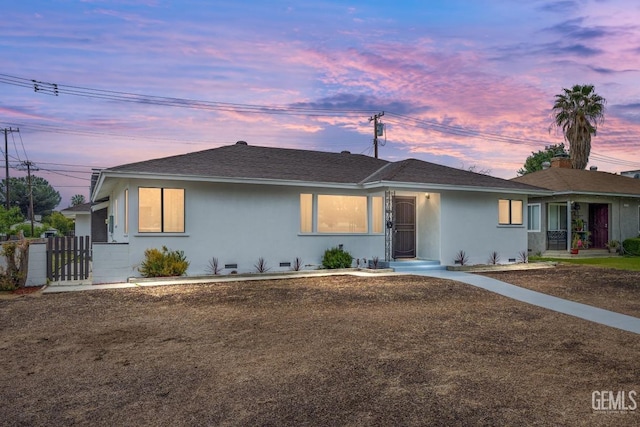 ranch-style home featuring a gate and stucco siding