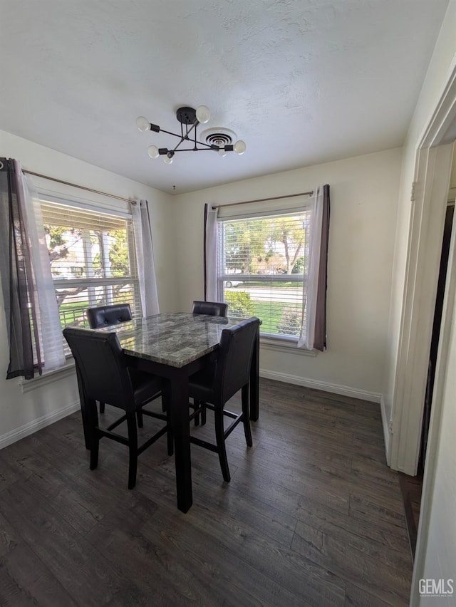 dining space with dark wood-type flooring, a healthy amount of sunlight, and baseboards