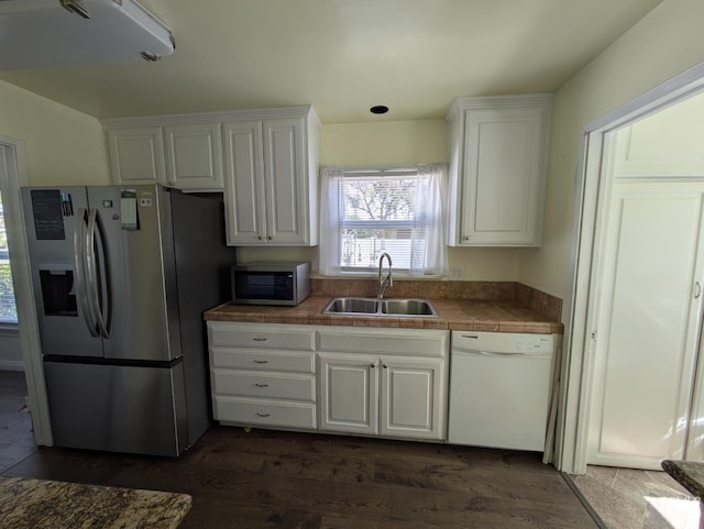 kitchen with dark wood finished floors, white cabinets, appliances with stainless steel finishes, and a sink