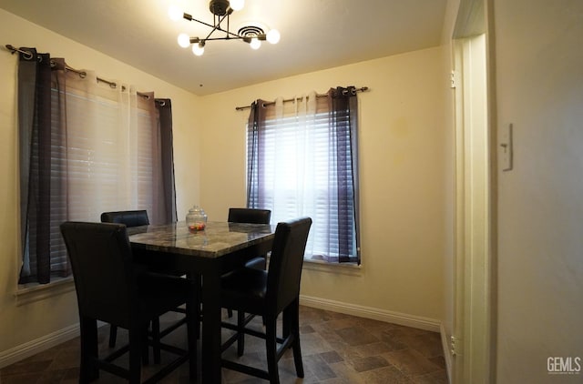 dining room with a wealth of natural light, baseboards, and a chandelier