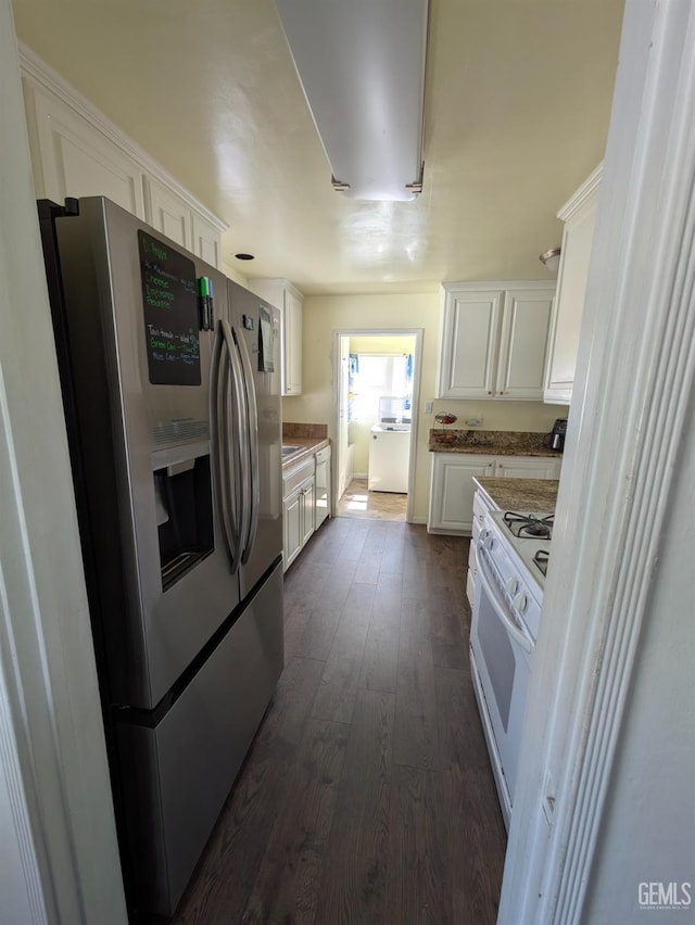 kitchen featuring washer / clothes dryer, dark wood-style floors, wall oven, stainless steel fridge, and white cabinets