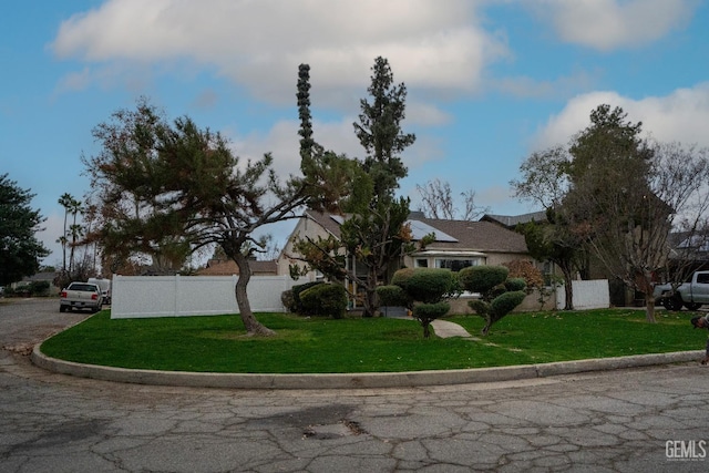 view of front facade with a front lawn and fence