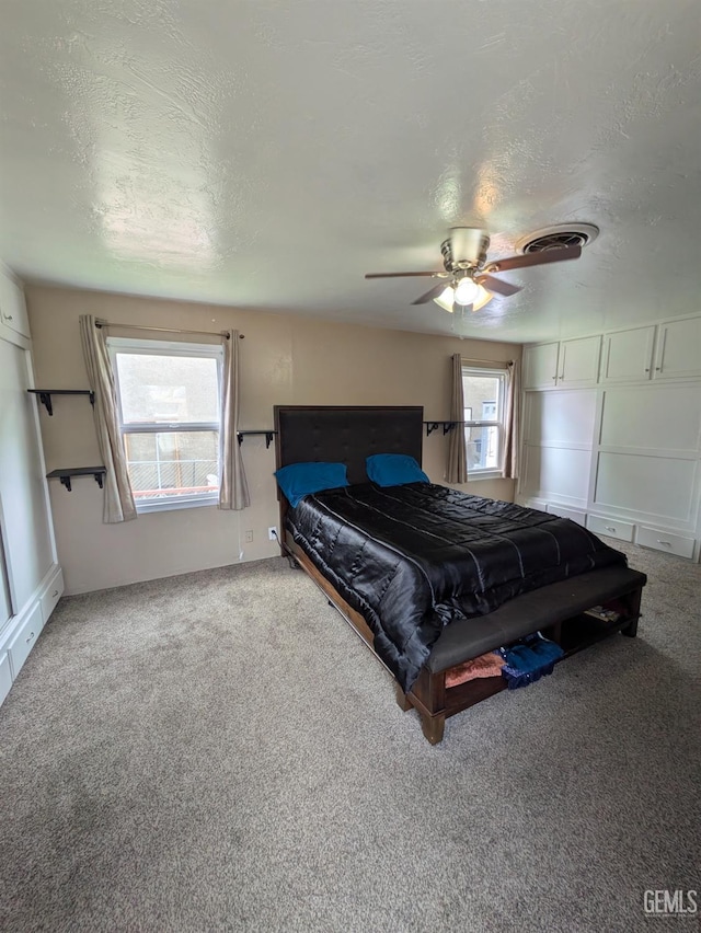 bedroom featuring ceiling fan, carpet flooring, and a textured ceiling