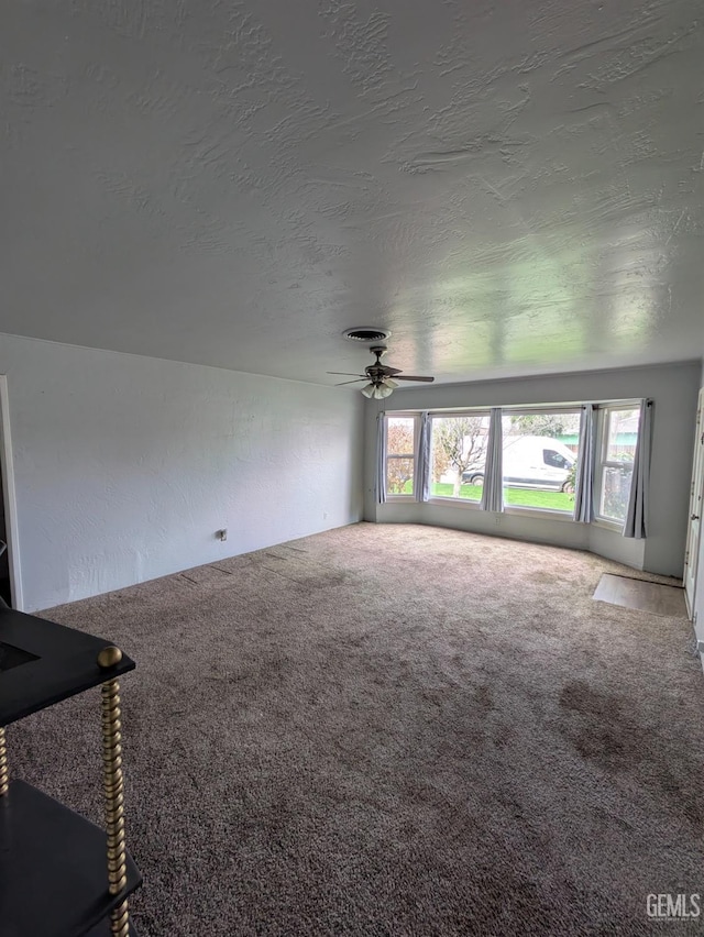 unfurnished living room with carpet, a wealth of natural light, and a textured ceiling