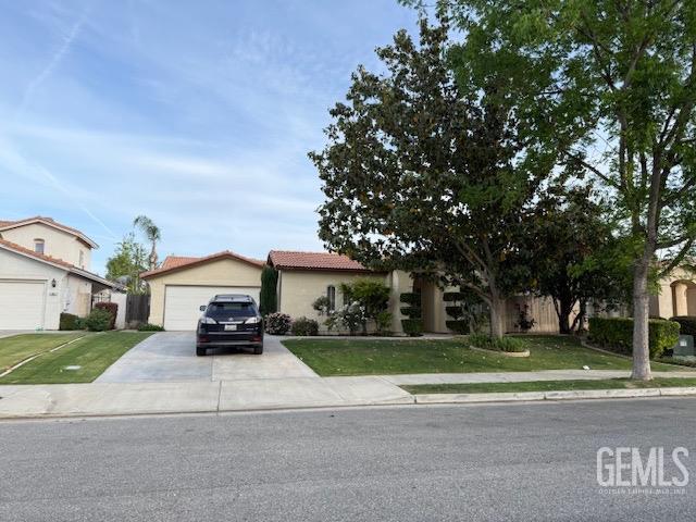 11615 Marazion Hill Ct, Bakersfield, CA 93311 - view of front facade featuring driveway, a tile roof, and a front lawn