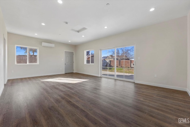 3409 Lotus Ln, Bakersfield, CA 93307 - unfurnished room with a wall unit AC, attic access, recessed lighting, and dark wood-type flooring