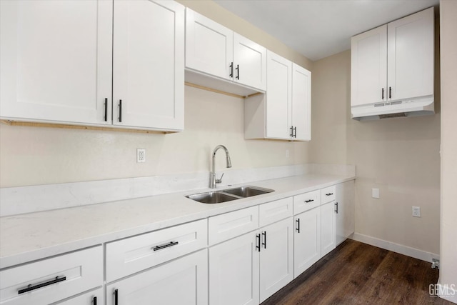 3409 Lotus Ln, Bakersfield, CA 93307 - kitchen with under cabinet range hood, dark wood-style flooring, and white cabinets