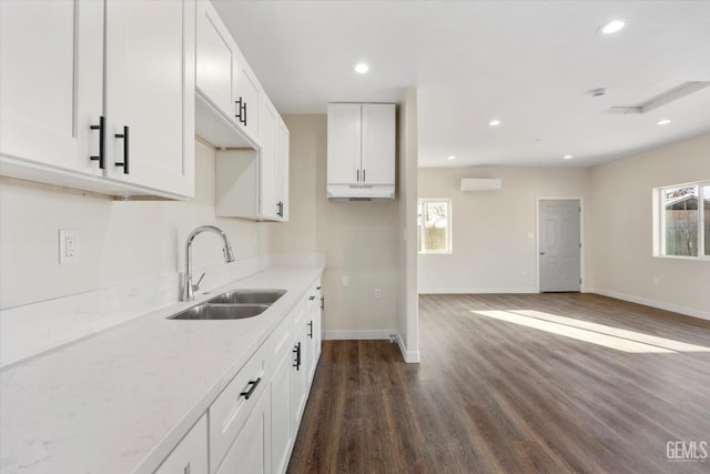 3409 Lotus Ln, Bakersfield, CA 93307 - kitchen featuring a wall unit AC, dark wood finished floors, recessed lighting, white cabinetry, and open floor plan