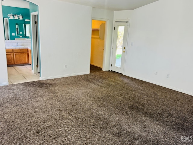 3614 White Sands Dr, Bakersfield, CA 93313 - spare room featuring light carpet, a sink, arched walkways, and baseboards