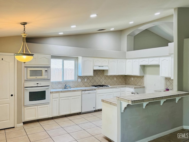 3614 White Sands Dr, Bakersfield, CA 93313 - kitchen featuring white appliances, tile countertops, a peninsula, tasteful backsplash, and white cabinetry