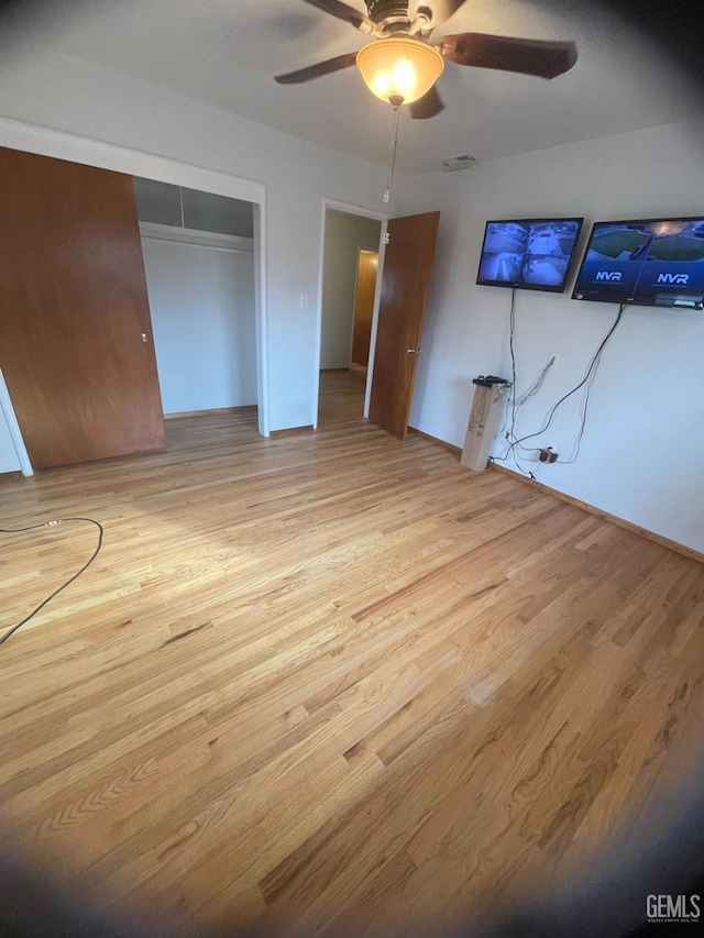 unfurnished bedroom featuring ceiling fan, a closet, and light hardwood / wood-style floors