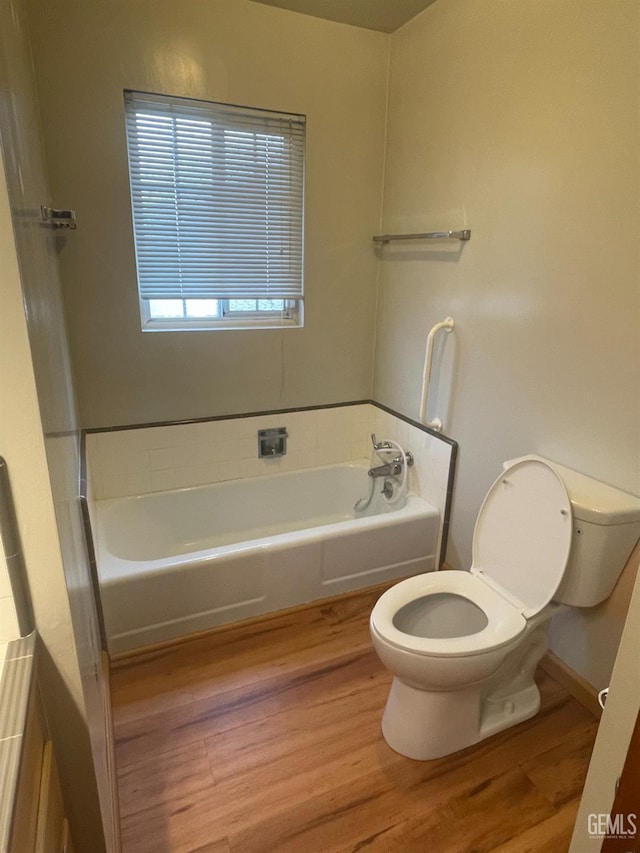 bathroom featuring toilet, a bath, and hardwood / wood-style flooring