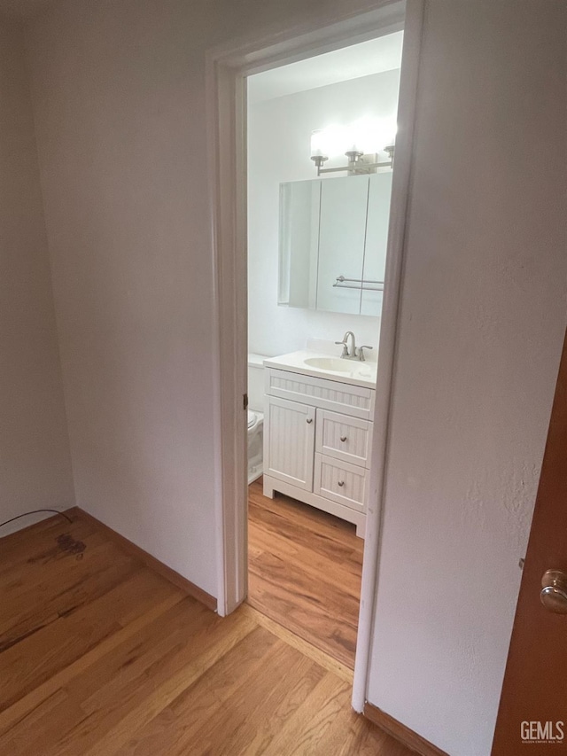 interior space featuring hardwood / wood-style floors, toilet, and vanity