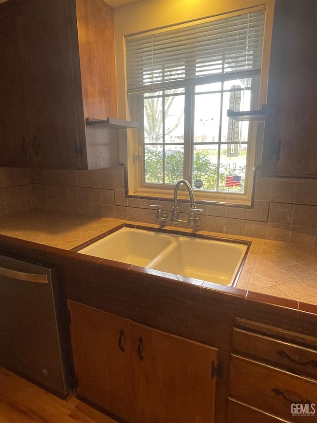 kitchen with decorative backsplash, dishwasher, and sink