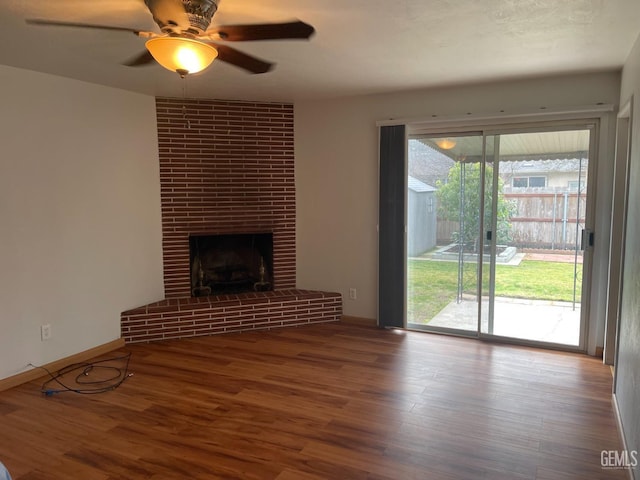 unfurnished living room with ceiling fan, wood-type flooring, and a fireplace