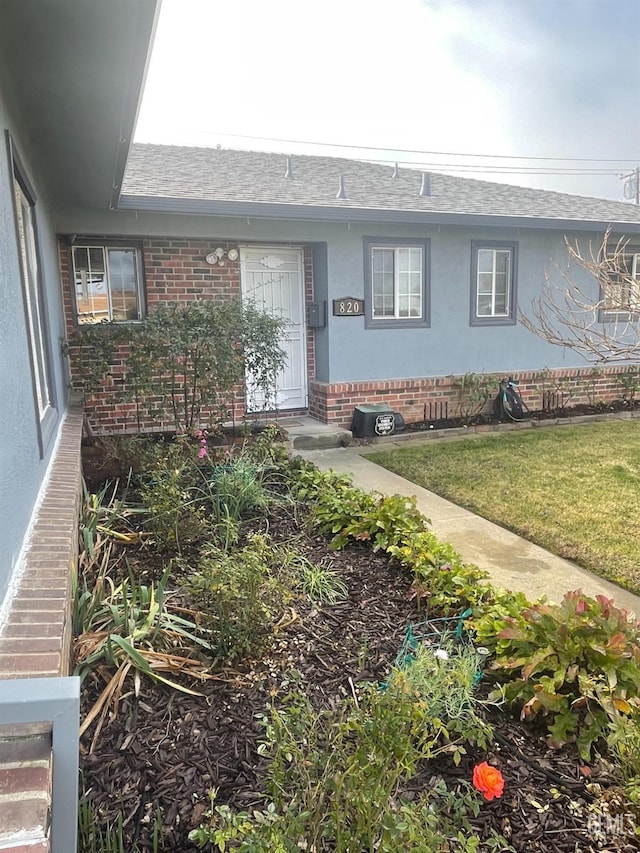 entrance to property with a lawn