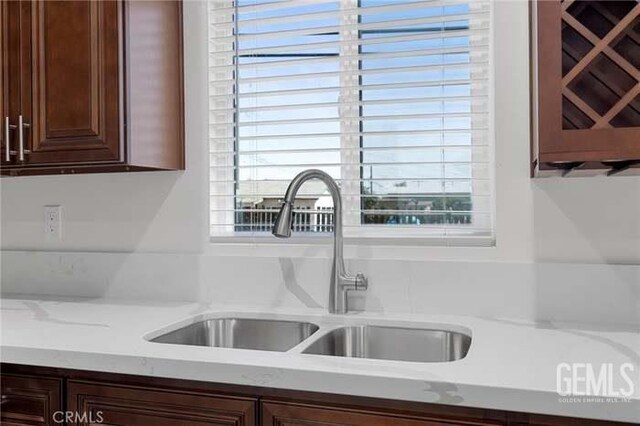 301 Kincaid St, Bakersfield, CA 93307 - kitchen with a sink, plenty of natural light, dark brown cabinets, and light stone countertops