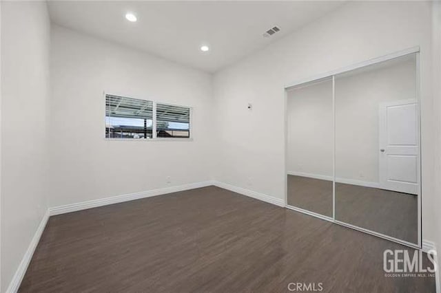 301 Kincaid St, Bakersfield, CA 93307 - unfurnished bedroom featuring dark wood-style floors, baseboards, a closet, and recessed lighting